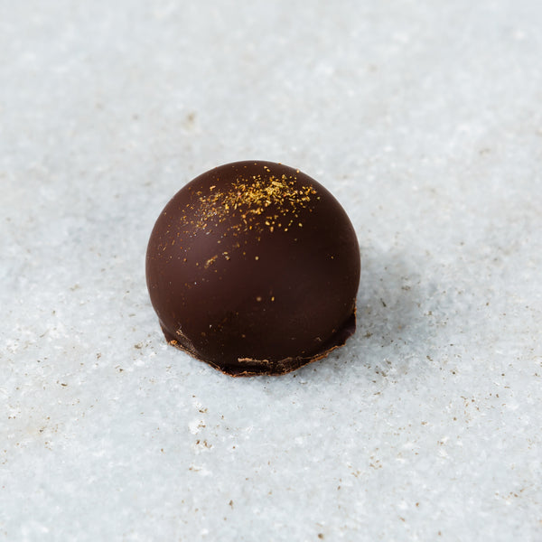 Tempered Chocolate cassis truffle topped with hibiscus powder..