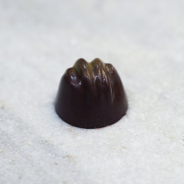 Tempered dark chocolate cherry cordial truffle accented with gold flakes.