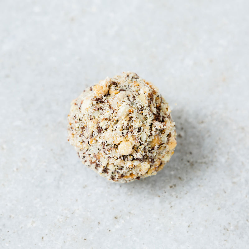 Tempered coffee walnut truffle covered in chopped walnuts. 