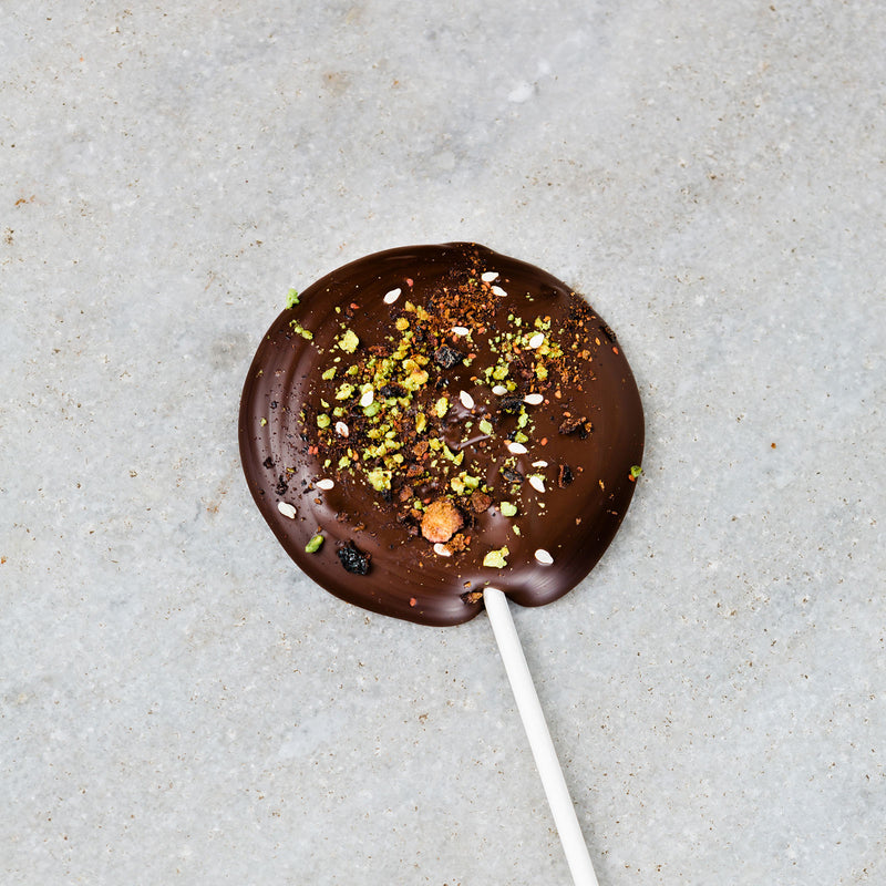 Tempered dark chocolate lollipop filled with chopped fruit and nuts.