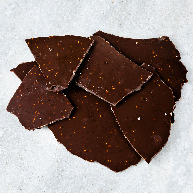 Thin, Tempered dark chocolate glass with toasted white and black sesame seeds incorporated throughout.